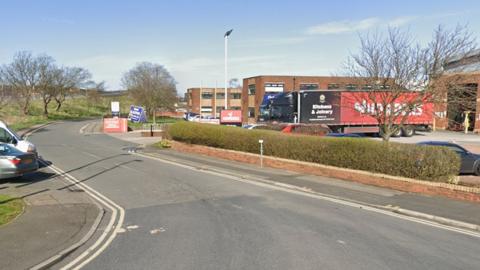 The end of Plymouth Road, which cut through an industrial estate with cars parked either side and a delivery lorry on a car park to the right