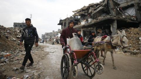 Palestinians continue their daily lives under harsh conditions amid the rubble of destroyed buildings in the Jabalia refugee camp in northern Gaza following the enforcement of a ceasefire agreement, on February 10, 2025