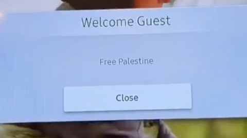 A pop up window on a hotel room TV saying "welcome guest - Free Palestine" with a button to "close" the window if selected on the TV remote.