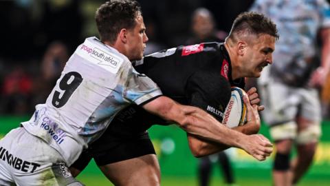 Andre Esterhuizen of Hollywoodbets Sharks scores a try despite Kieran Hardy of Ospreys