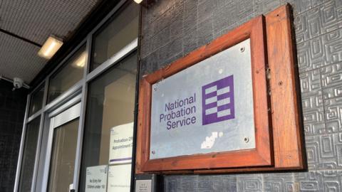 The entrance to a probation service building showing a plaque on the side of a door reading 'National Probation Service'