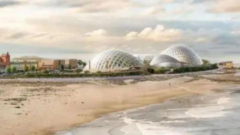 Artist's impression shows three large, white biodomes standing next to a sandy beach on a bright but cloudy day.