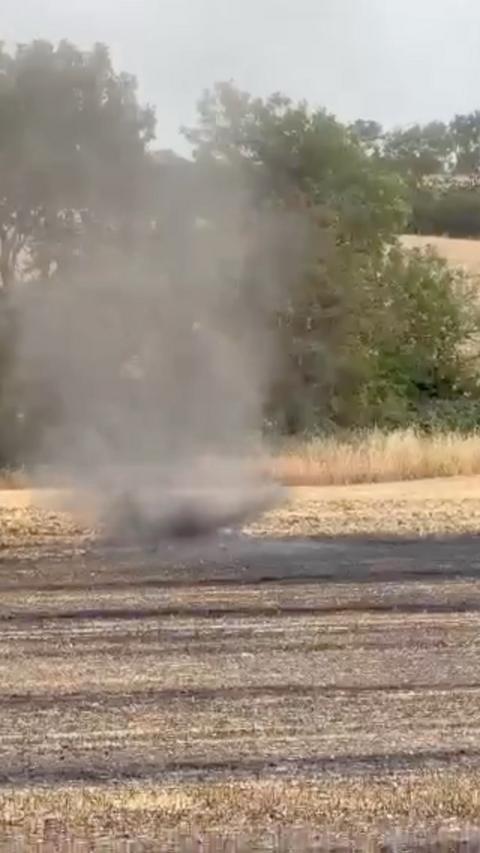 A small whirlwind swirls on a newly harvested field