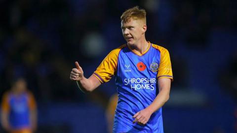 Sam Clucas gives a thumbs-up sign with his right hand while playing for Shrewsbury against Newport last season