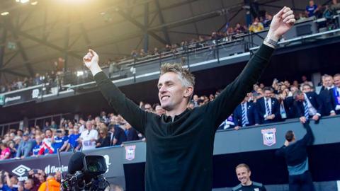 Kieran McKenna hold arms aloft in front of Ipswich fans
