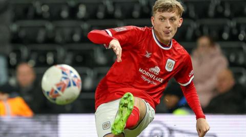 Crewe's Charlie Finney crosses the ball left footed during a game