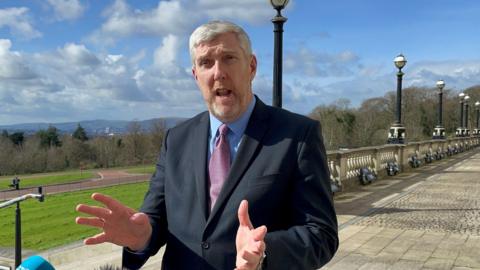 Infrastructure Minister John O'Dowd outside Parliament Buildings, Stormont in March