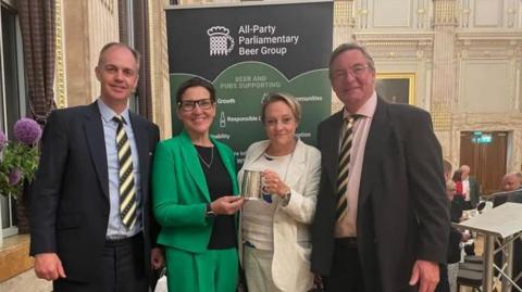 Piers Thompson, St Austell Brewery's external relations director; Tonia Antoniazzi MP, chair of the All Party Parliamentary Beer Group; Georgina Young, St Austell Brewery's brewing director; and Paul Harbottle, St Austell Brewery's commercial director, pose for a photo after Georgina won Brewer of the Year at the All Party Parliamentary Beer Group's annual dinner.