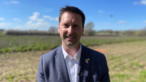 A man in suit stood in a field.
