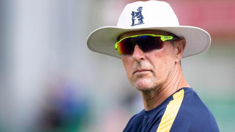 Mark Robinson wearing an England hat and sunglasses