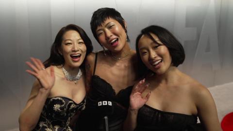 Arden Cho, May Hong and Ji-young Yoo are smiling and waving at the camera