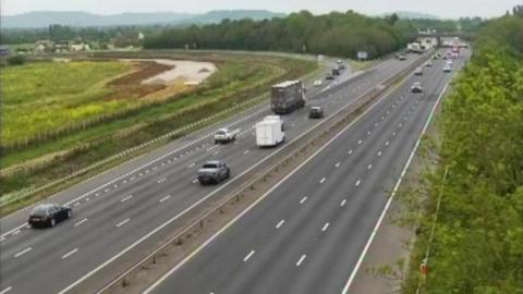 A screenshot taken from a traffic camera showing cars driving along the M5 approaching Tewkesbury.