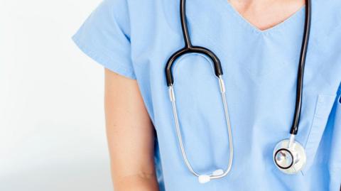 A generic picture of a female medical person, with a stethoscope hanging around their neck.