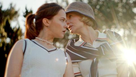 Carey Mulligan whispering to Cailee Spaeny in a still from Beef