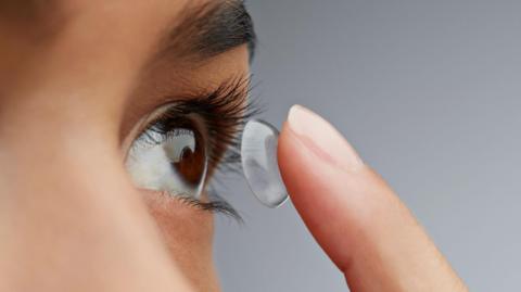 a lady putting in a contact lens
