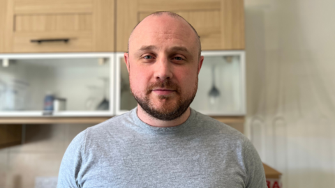 A man in a grey top looking into the camera