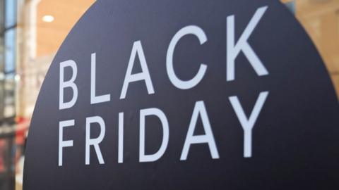 A shop window sign with the words Black Friday