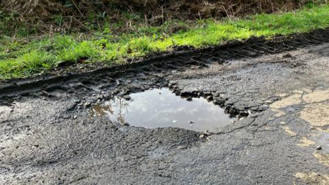 Pothole in road filled with water