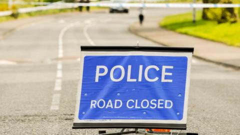 A police sign closing a road during a security alert - stock photo