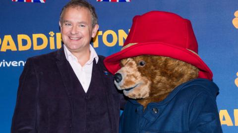 Hugh Bonneville with someone in a Paddington costume