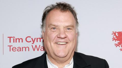 Syr Bryn Terfel yn gwenu'n braf