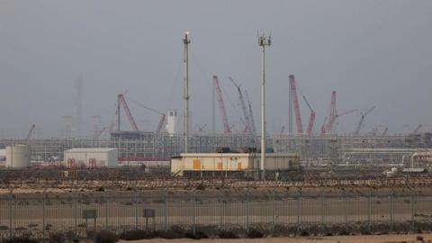 Ras Laffan LNG refinery, with towers and cranes visible in the background.