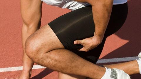 Photo of an athlete holding their leg in pain