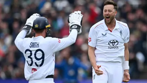 England players Jamie Smith (left) and Ollie Robinson (right) celebrate a wicket