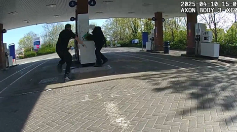 A still from a police body cam video showing Sgt Thompson rushing a man before tackling him