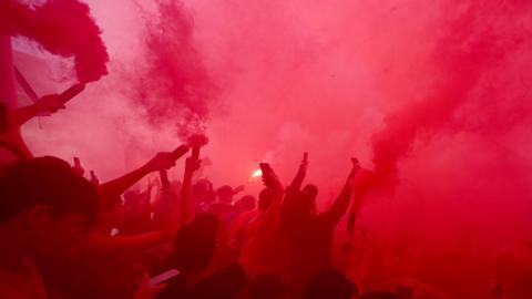 Liverpool fans set off red coloured flares outside Anfield