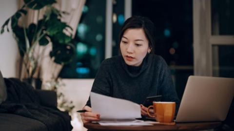 Young woman looks at paperwork at a desk