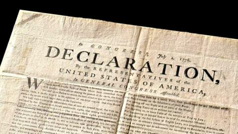 A copy of the US Declaration of Independence. The word "declaration" can be seen in capital letters on the document, which has various folds and creases.