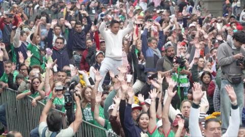 Crowd with hands up doing celebratory wave