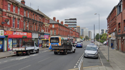 A street view image of Stanley Avenue. The street is lined with shops on either side.