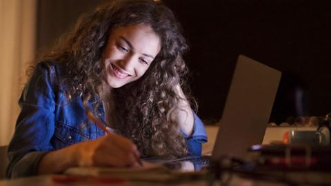 A girl is studying in front of a computer