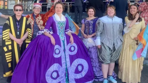 Performers in colourful costumes gathered on the steps of the Senedd in protest against cuts in May