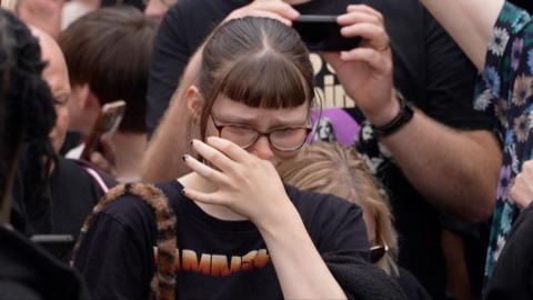 A fan cries during Ozzy Osbourne's funeral parade