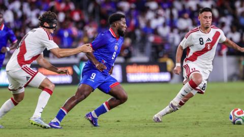 Haiti's Duckens Nazon (centre) in action against Peru