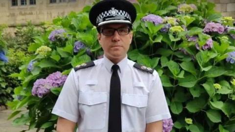 Ch Supt Daniel Greenwood - a bespectacled police officer in uniform, pictured against a bush