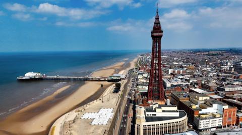 View of Blackpool from the air, showing the beach, Blackpool Tower and the piers 