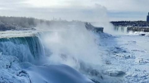 Niagara Falls appears to have frozen as ice and snow tips over the edge rather than the normal running water