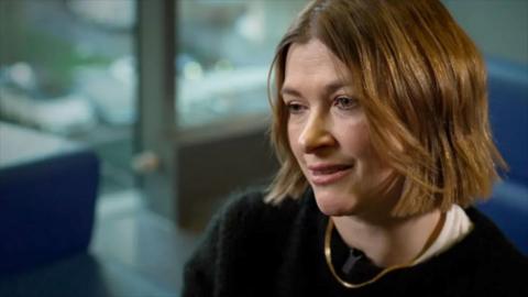 A close range photo of a woman, Nicki Guy, with a brown bob and black top.