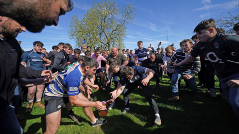 People rugby tackling each other during a game of bottle kicking in Leicestershire