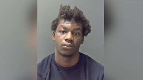 A custody picture of Leon Bangura. He is looking directly at the camera and is wearing a dark pullover.