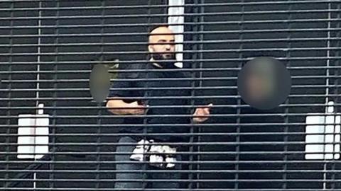 An image verified by the BBC, taken near the scene this morning, shows a man believed to be the suspect with items around his waist