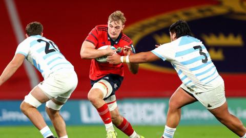 Francisco Moreno wearing a number three shirt attempts to tackle Munster's Gavin Coombes