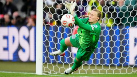 Goalkeeper Hannah Hampton, in green, dives while making a save at the Euro 2025 final