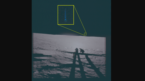 A photo from the surface of the Moon. It shows the shadows of two astronauts, and in the distance what looks like a flash of blue light. It is highlighted and englarged