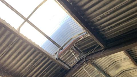 The hole in the roof of a farm outbuilding. The sunlight is pouring through where Jacob fell.
