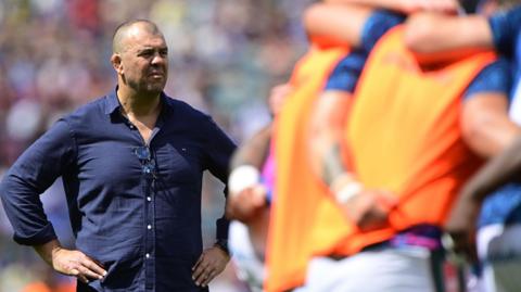 Michael Cheika with hand on hips as he watches his Leicester Tigers players warm up